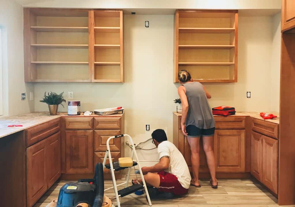 DIY couple getting ready to paint kitchen furniture