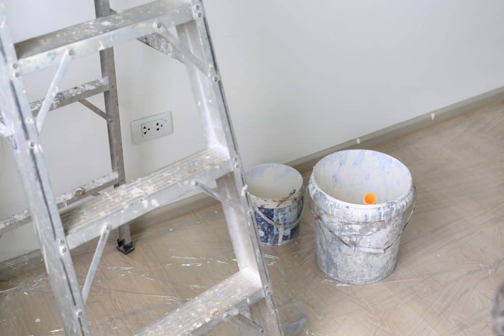 An aluminium painter's ladder along with paint tins