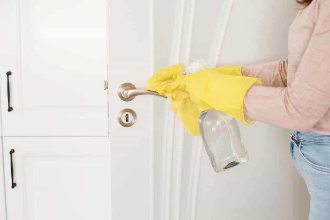 Cleaning a door whilst wearing protective gloves