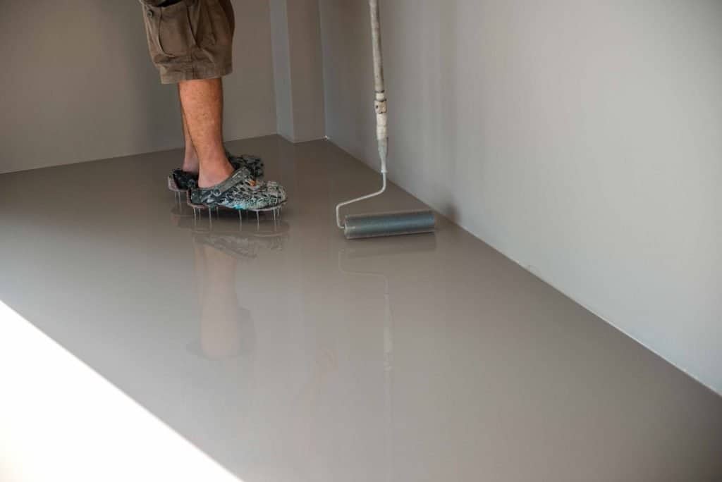 Concrete coating getting applied by painting company