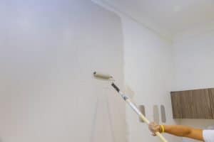 A house painter painting an indoor wall. For article when is the best time to paint indoors